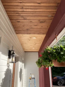 Front porch in CT with natural wood ceiling being stained.